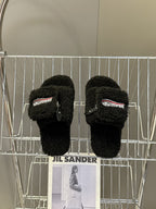 Balenciaga black fuzzy slide sandals on display rack, zipper detail