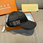 Black Louis Vuitton baseball cap with front logo band and curved brim, angled view
