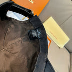 Black Louis Vuitton cap with visible woven fabric seam and neck strap tag