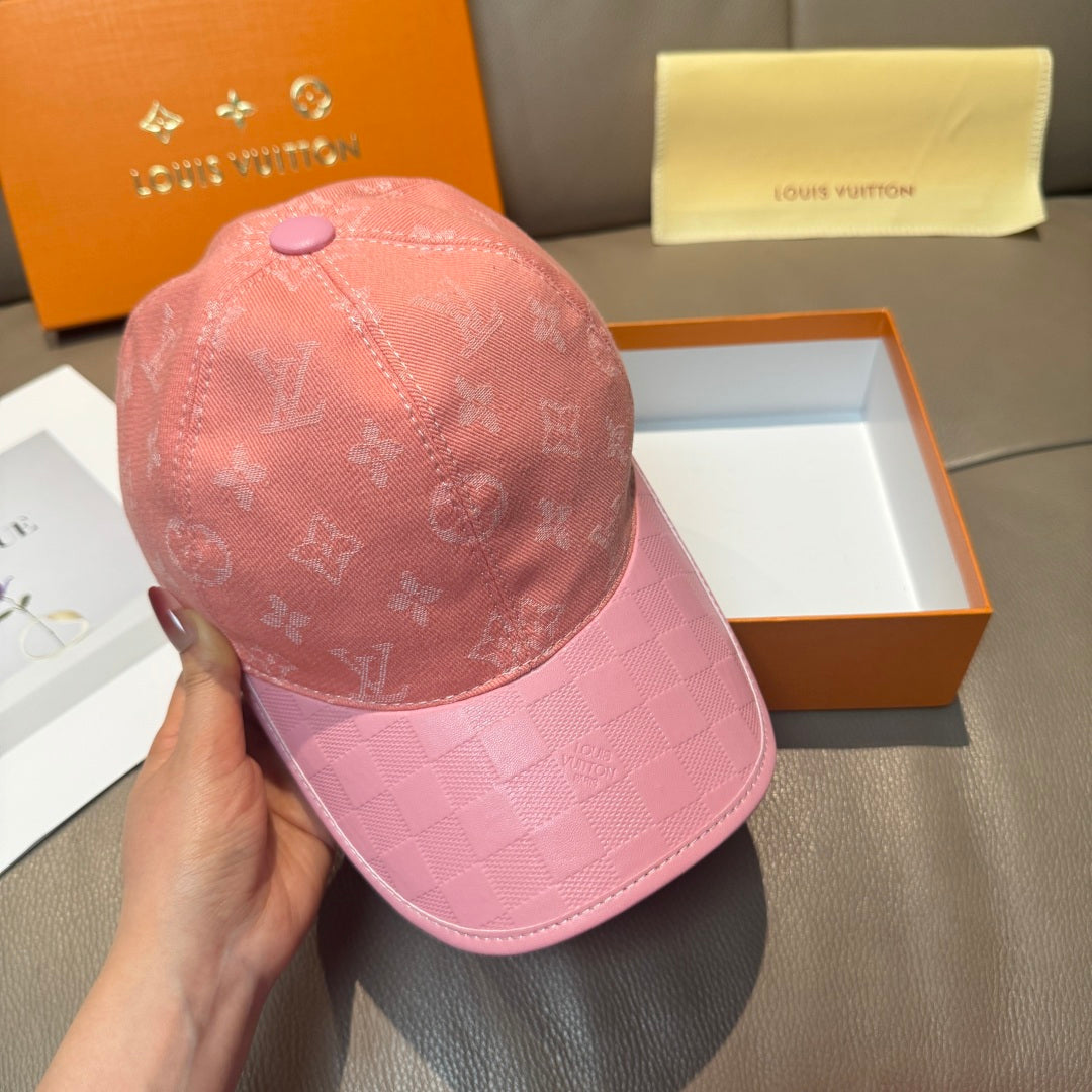 Pink monogram baseball cap held in hand, with checkered brim and purple button
