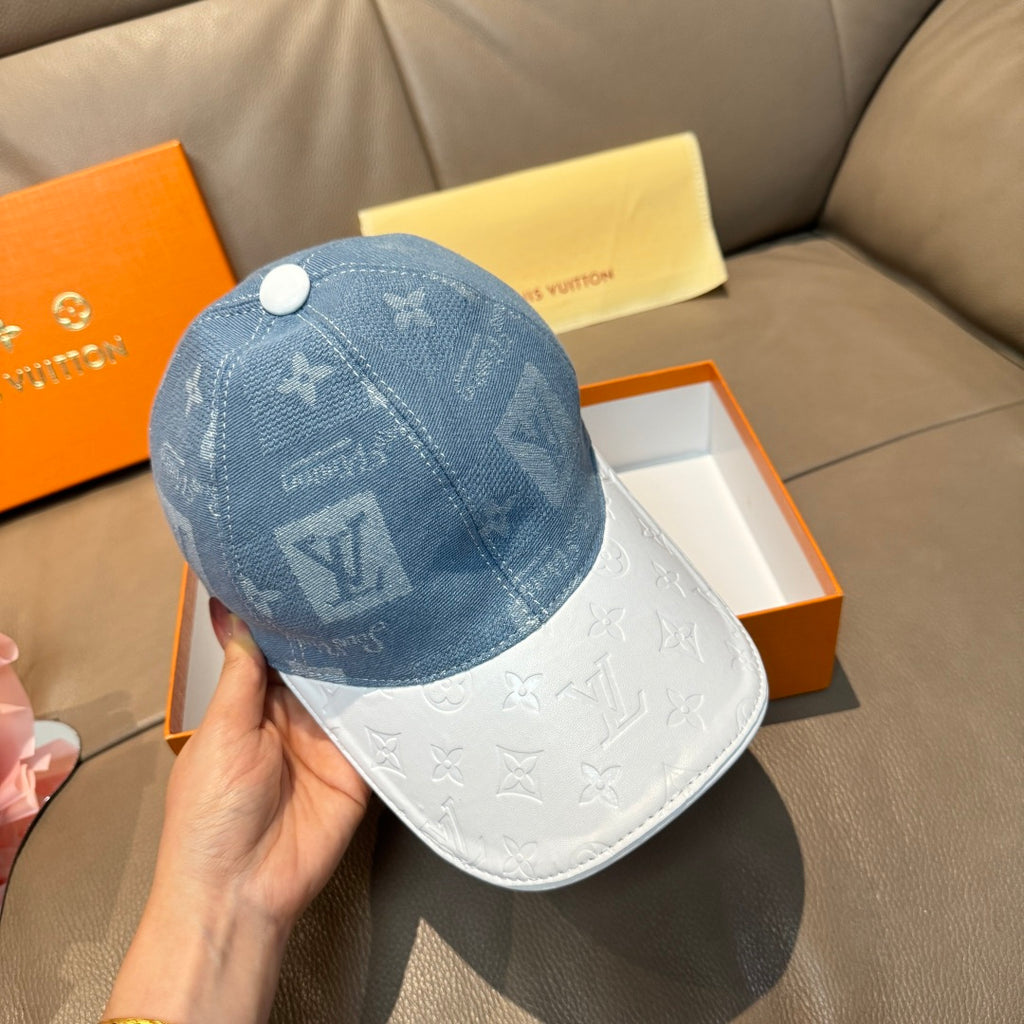 Louis Vuitton cap held in hand: blue monogram crown with white contrast brim