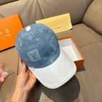 Louis Vuitton cap held in hand: blue monogram crown with white contrast brim