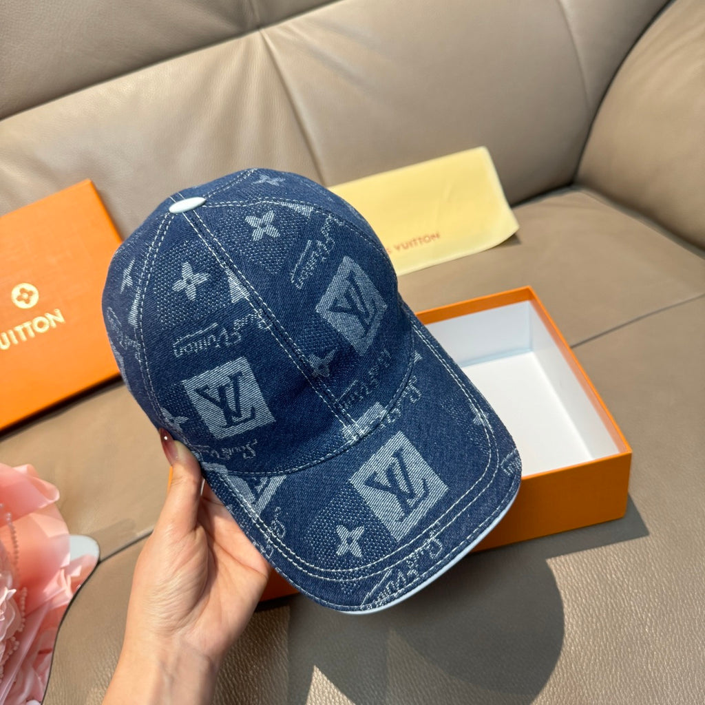 Denim blue monogram baseball cap held in hand, angled side view