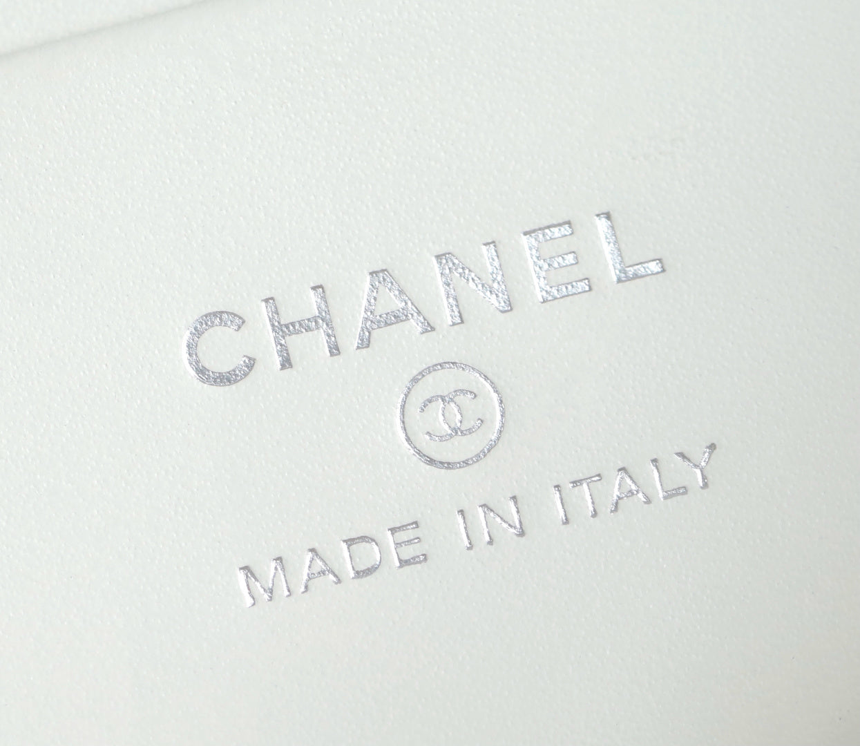 Embossed CHANEL and MADE IN ITALY mark on white leather