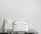 White quilted Chanel mini bag with top handle and chain crossbody strap