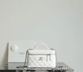 White Chanel quilted mini bag with top handle, chain strap, and front logo