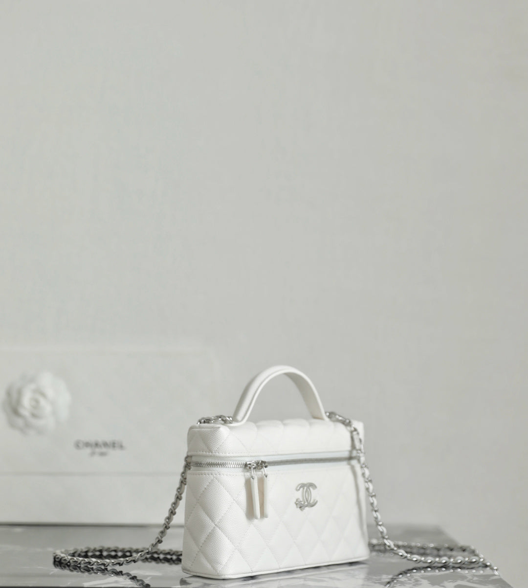 White Chanel mini bag with top handle and dangling chain strap