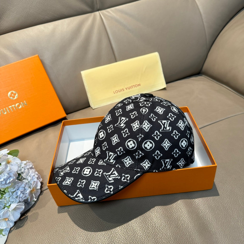 Louis Vuitton cap on gift box, black crown with repeating white monogram pattern.