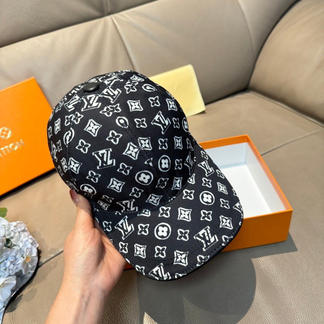 Louis Vuitton cap held by hand, black with white monogram print and curved visor.