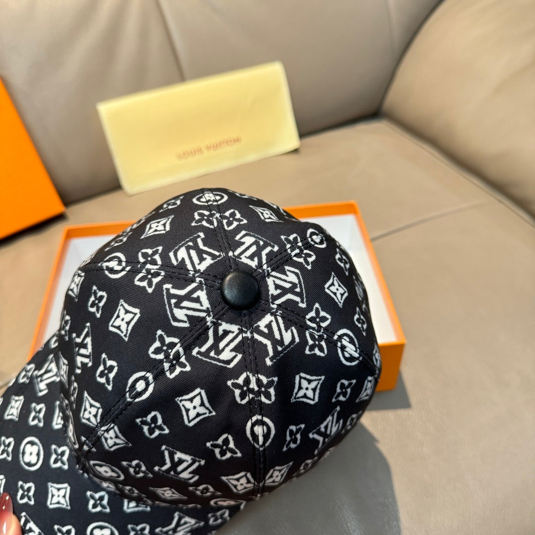 Louis Vuitton cap close-up, black with white monogram pattern and round top button.