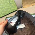 Black Gucci monogram cap interior showing strap, size label, and hanging tag