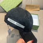 Black Gucci monogram cap, side close-up with white GUCCI logo band