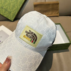 White Gucci baseball cap with GG monogram and The North Face logo patch
