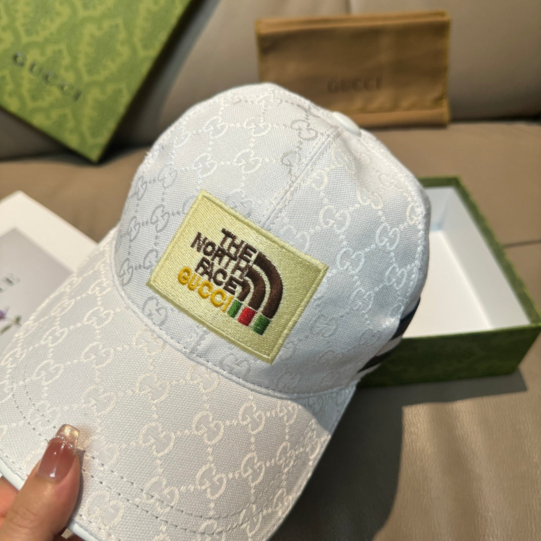 White Gucci baseball cap with GG monogram and The North Face logo patch
