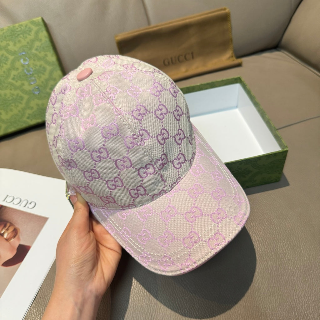 Light pink Gucci GG baseball cap held in hand, front panel with monogram pattern