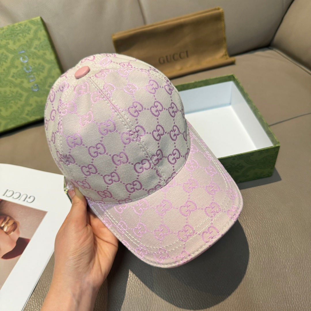 Light pink Gucci GG baseball cap held in hand, front panel with monogram pattern