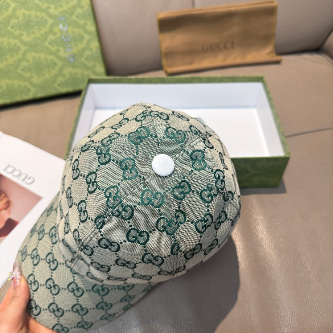 Teal Gucci GG monogram baseball cap with white snap button, top view.