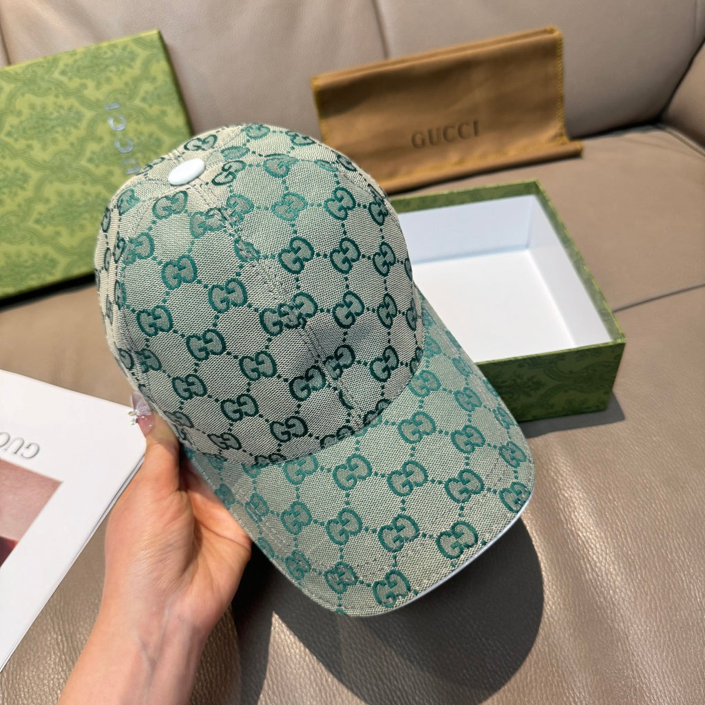 Teal Gucci GG monogram baseball cap, curved brim, front view held in hand.
