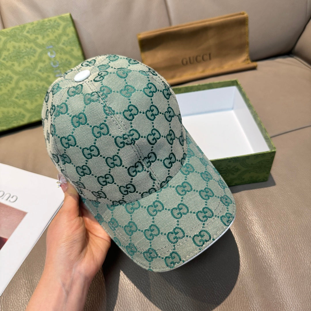 Teal Gucci GG monogram baseball cap, curved brim, front view held in hand.