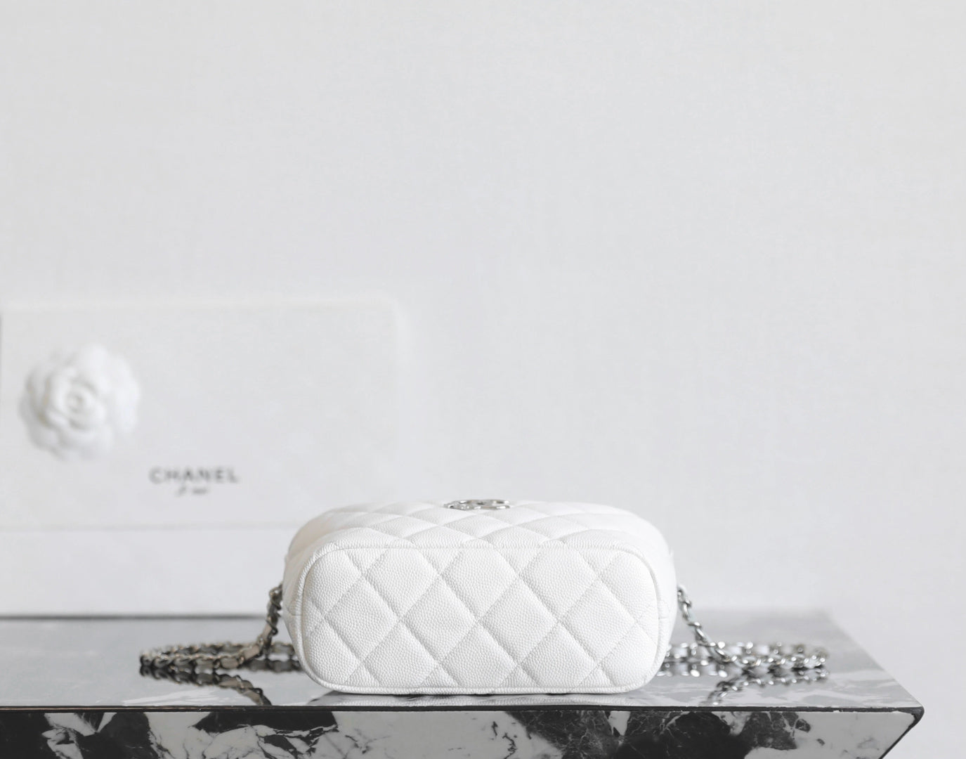 Chanel white quilted crossbody bag with chain strap and front logo
