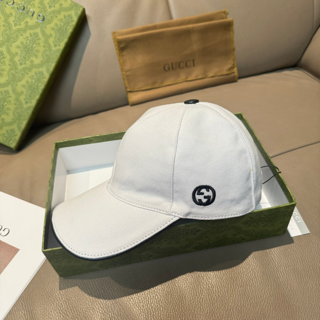 Gucci white canvas cap with black GG logo on front.