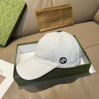 Gucci white canvas cap with black GG logo on front.