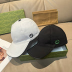 White and black Gucci baseball caps with GG logos, side-by-side