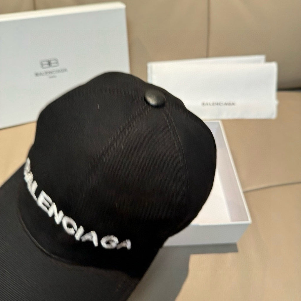 Balenciaga black baseball cap with textured crown and faux pearl top button