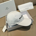 White baseball cap with partial BALENCIAGA logo on side