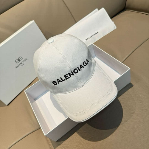 White Balenciaga baseball cap with embroidered front logo and curved brim.