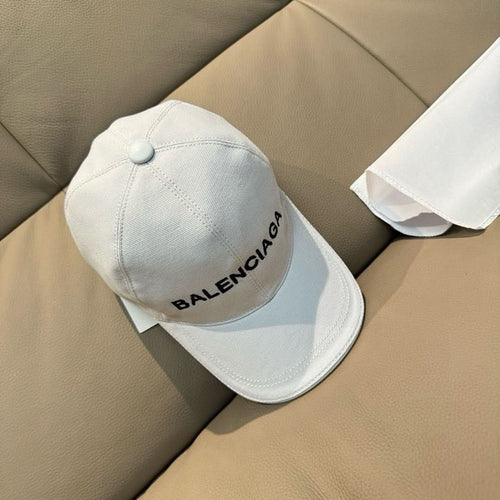 White Balenciaga baseball cap with embroidered logo and curved brim.