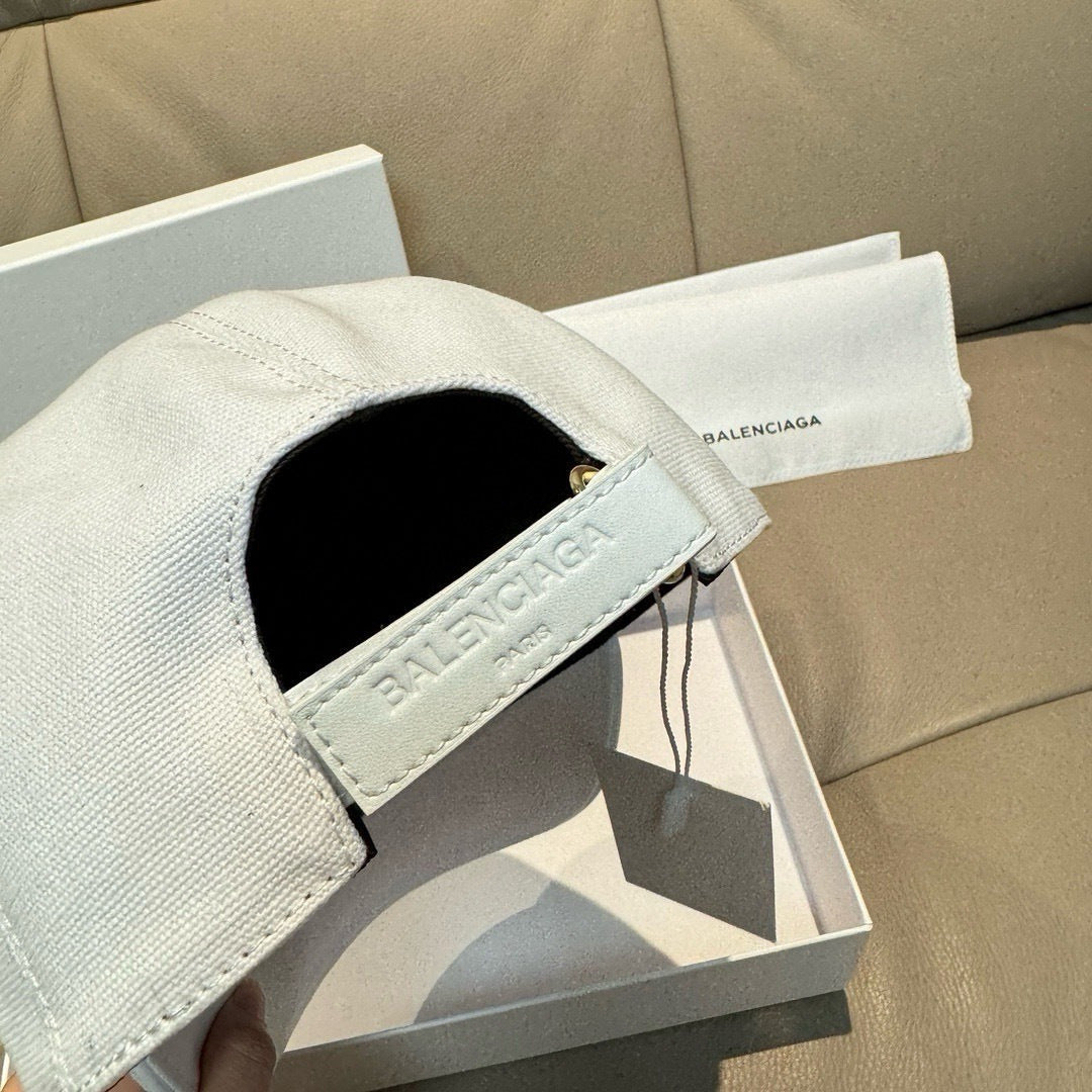 White Balenciaga baseball cap with adjustable strap and interior lining.