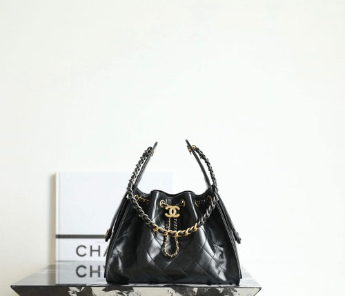 Chanel quilted leather bag in dark tone with gold chain handles and tassel charms