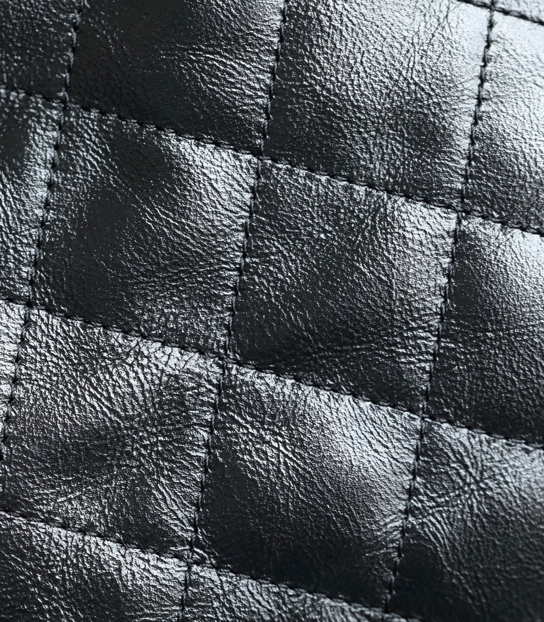 Chanel quilted leather panel with stitched diamond pattern in dark tone