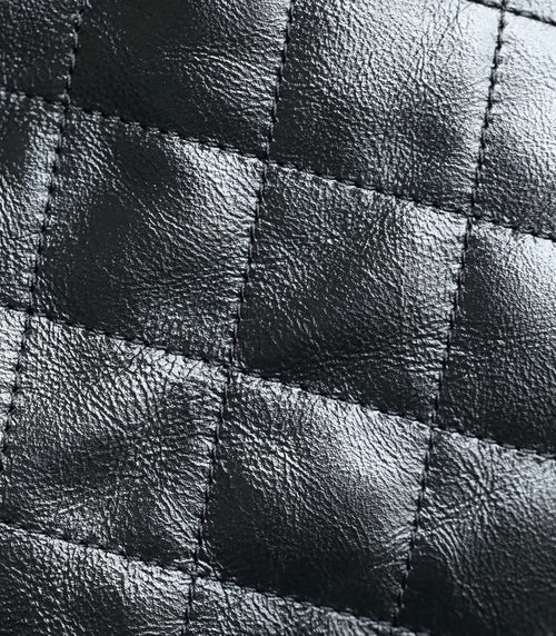 Chanel quilted leather panel with stitched diamond pattern in dark tone