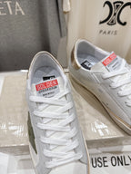 Golden Goose luxury sneakers: white pair with gold heel tabs and red logo tongue label
