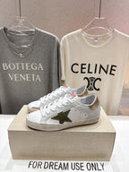 Golden Goose luxury sneakers: white laced shoes with green star emblem on the side