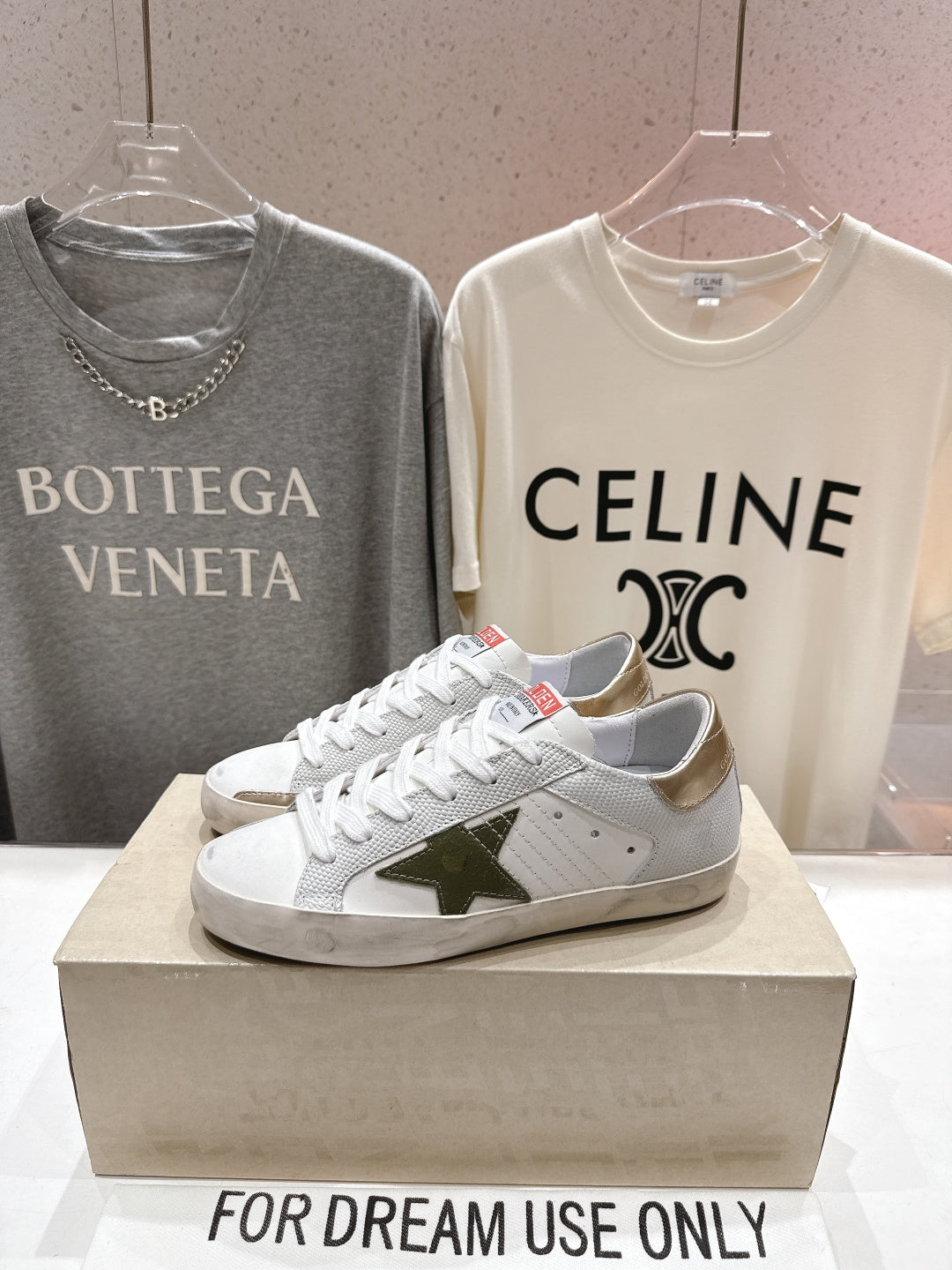 Golden Goose luxury sneakers: white laced shoes with green star emblem on the side