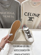 White sneakers with leopard laces; one shows textured tan outsole bottom