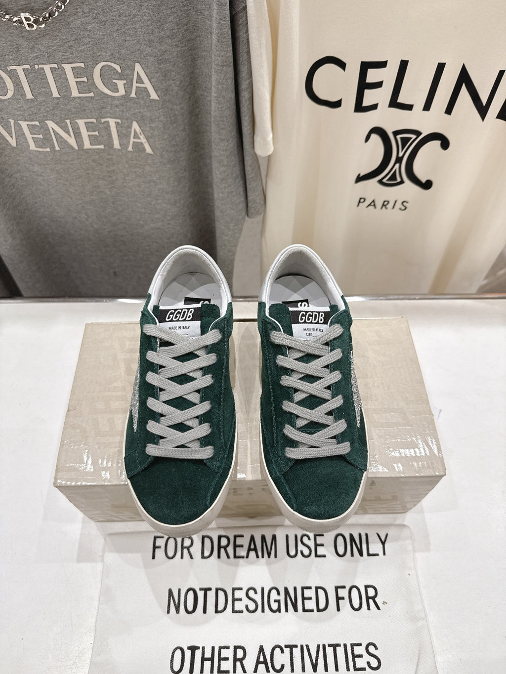 Pair of dark green suede Golden Goose sneakers with white lace-up front and rubber sole