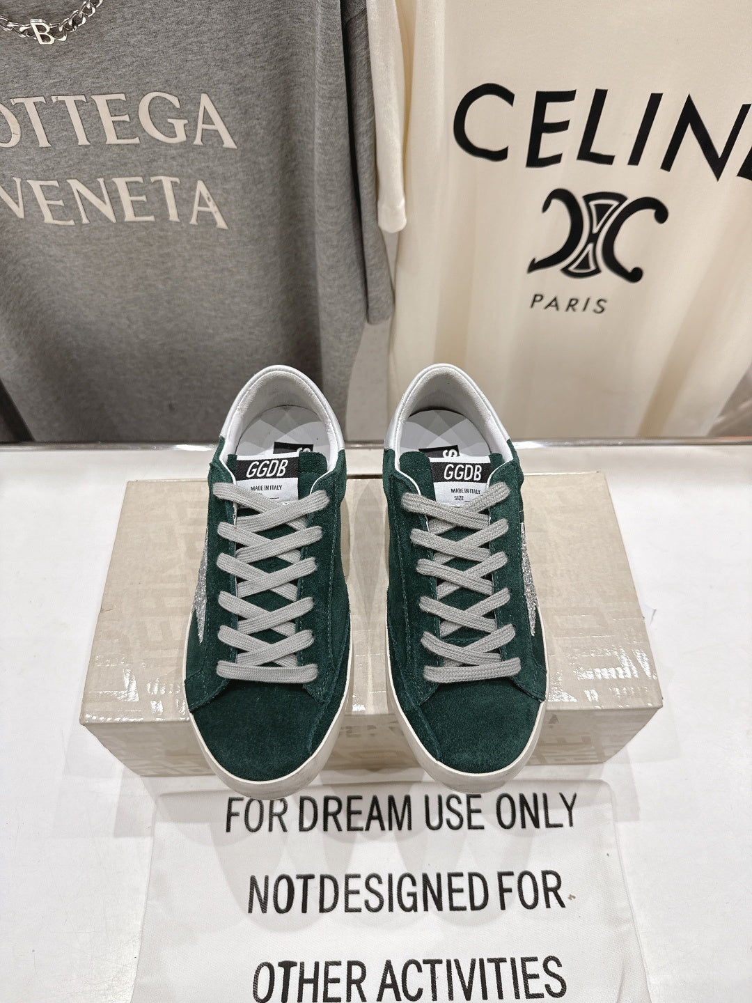 Pair of dark green suede Golden Goose sneakers with white lace-up front and rubber sole