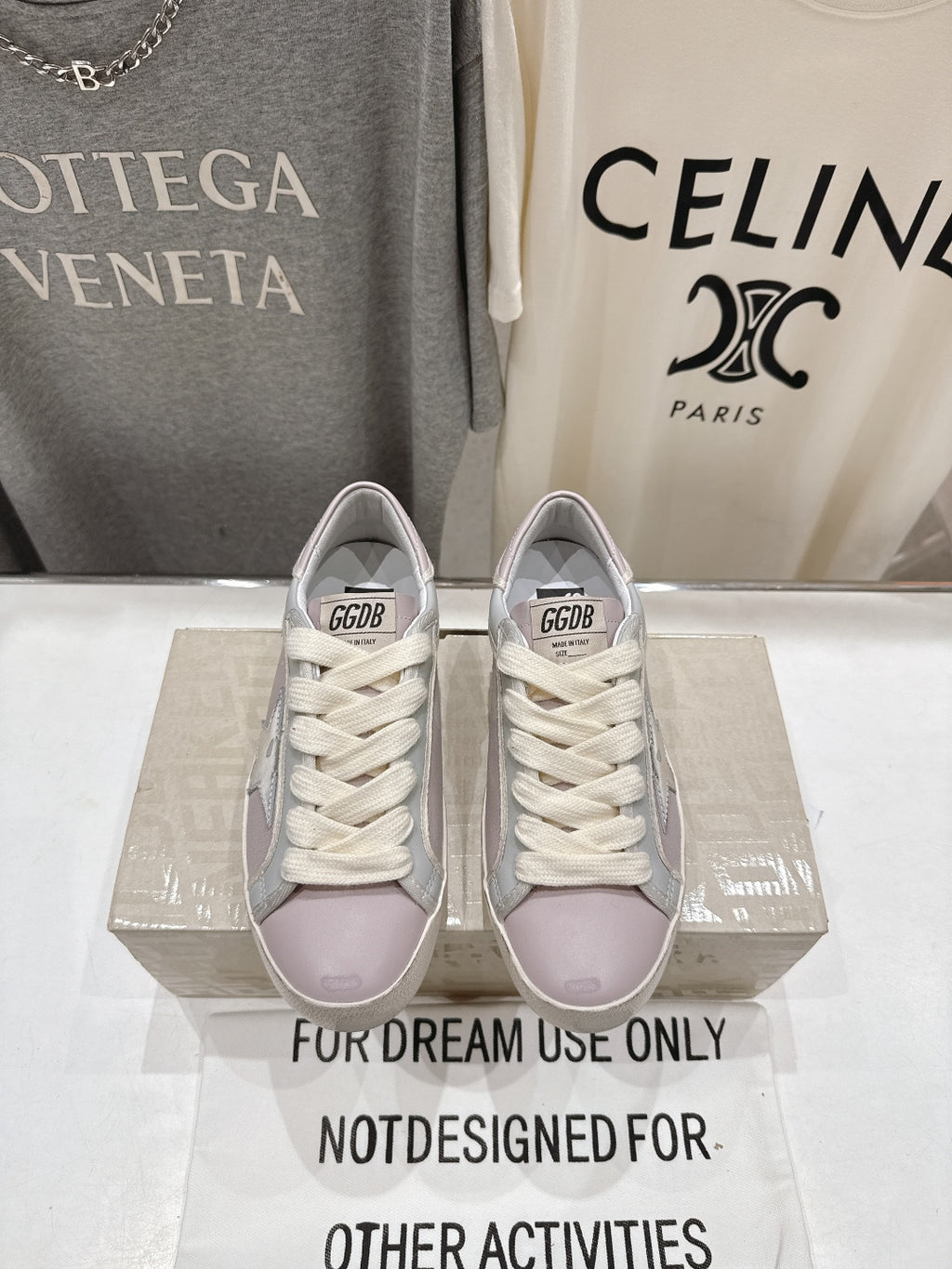 Lilac and white lace-up sneakers with star detail, worn together in a front view