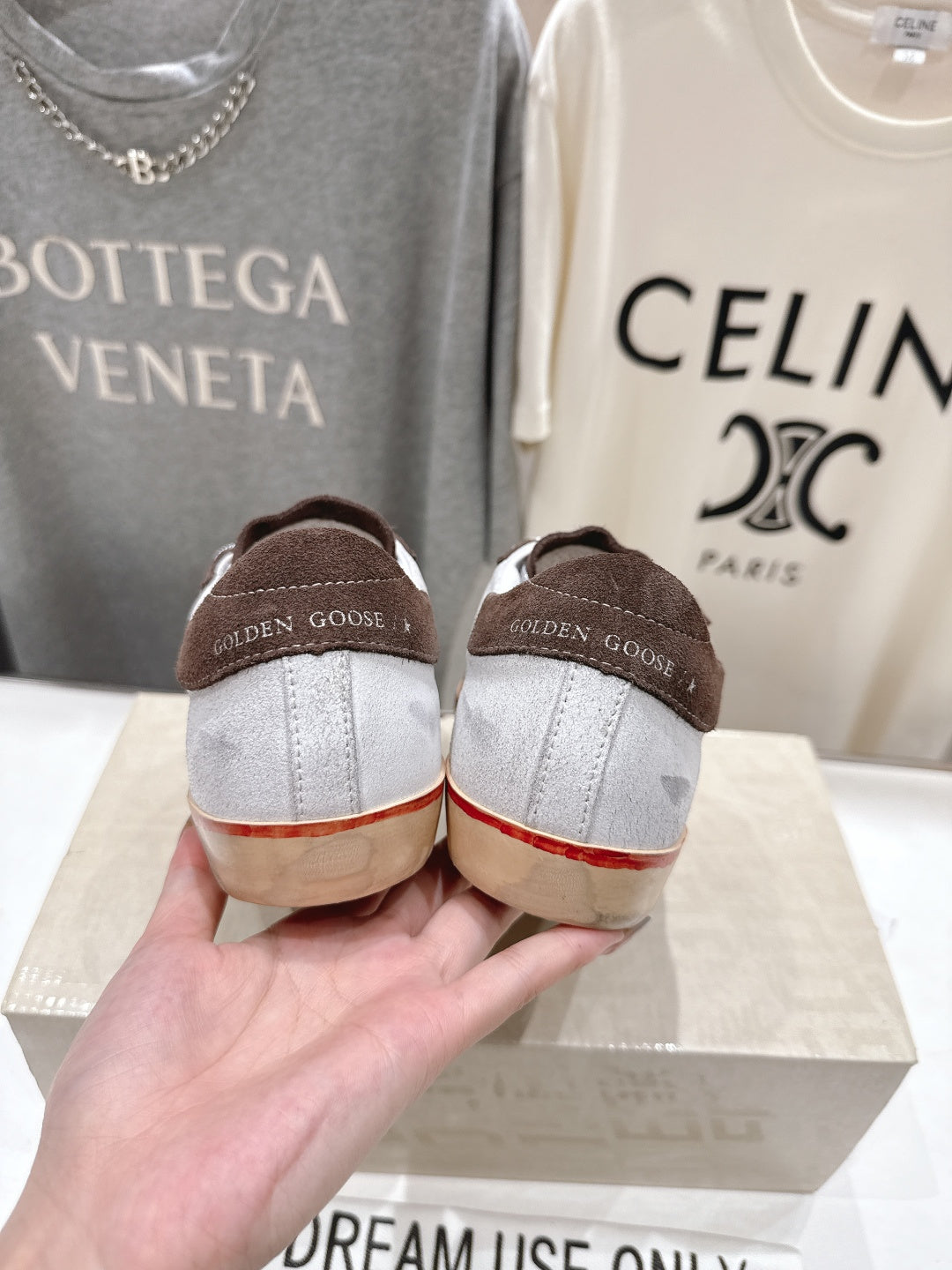 Back view of brown suede Golden Goose sneakers with heel lettering and cream soles.