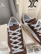 Side view of brown and white lace-up sneakers with white laces and cream rubber sole.