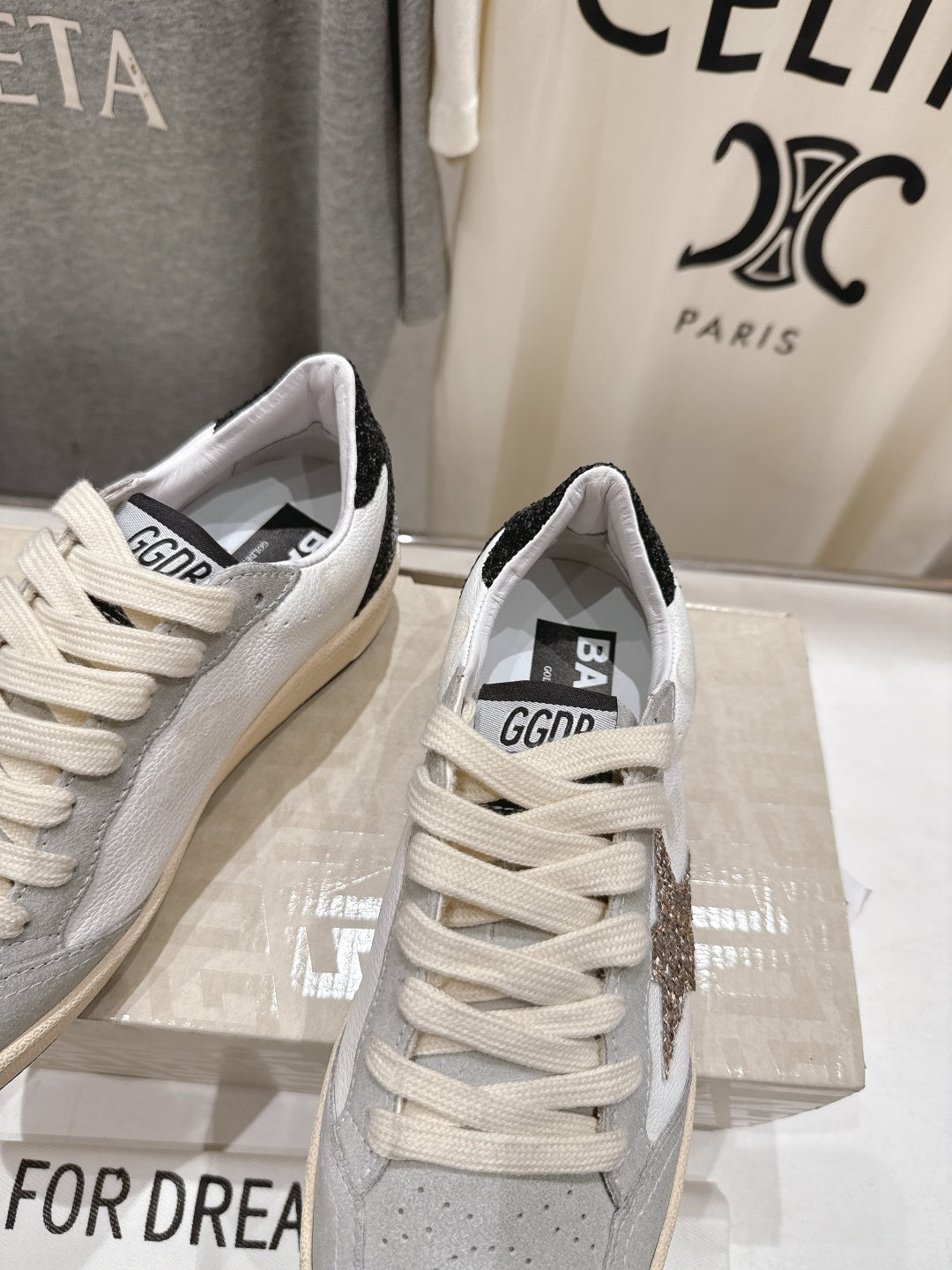 White sneakers close-up showing logo patch on tongue and heel
