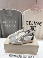 White and light gray low-top sneakers with star detail and cream laces