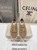 Tan low-top sneakers with perforated toe, gold lace-up and white rubber sole