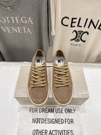 Tan low-top sneakers with perforated toe, gold lace-up and white rubber sole