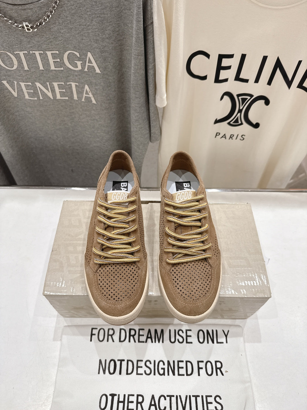 Tan low-top sneakers with perforated toe, gold lace-up and white rubber sole