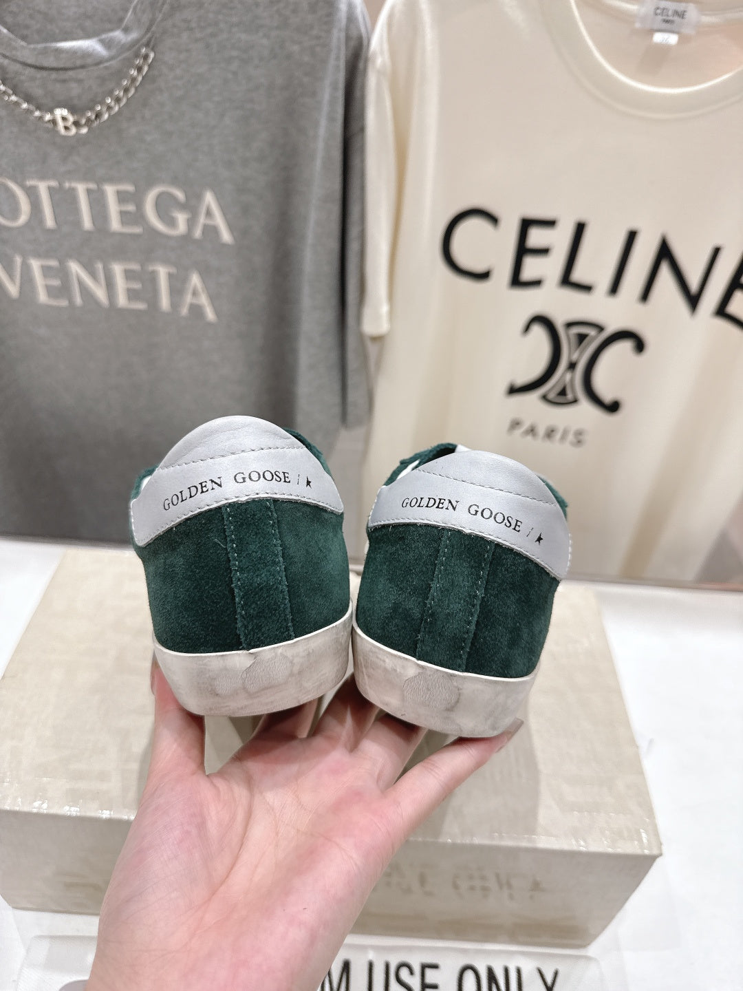Back view of dark green suede Golden Goose sneakers with white heel tab detailing